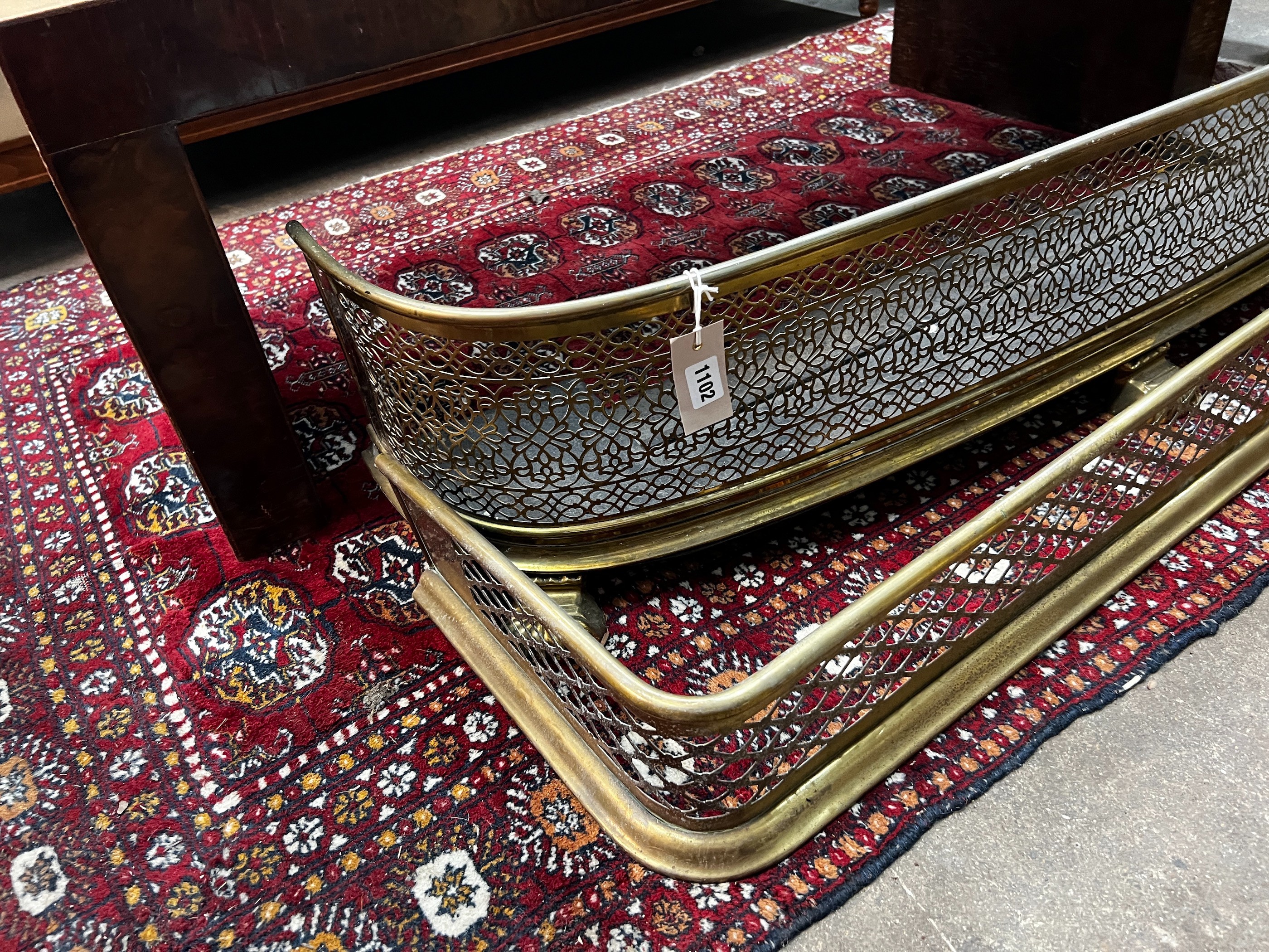 Two Victorian pierced brass fenders, larger width 123cm
